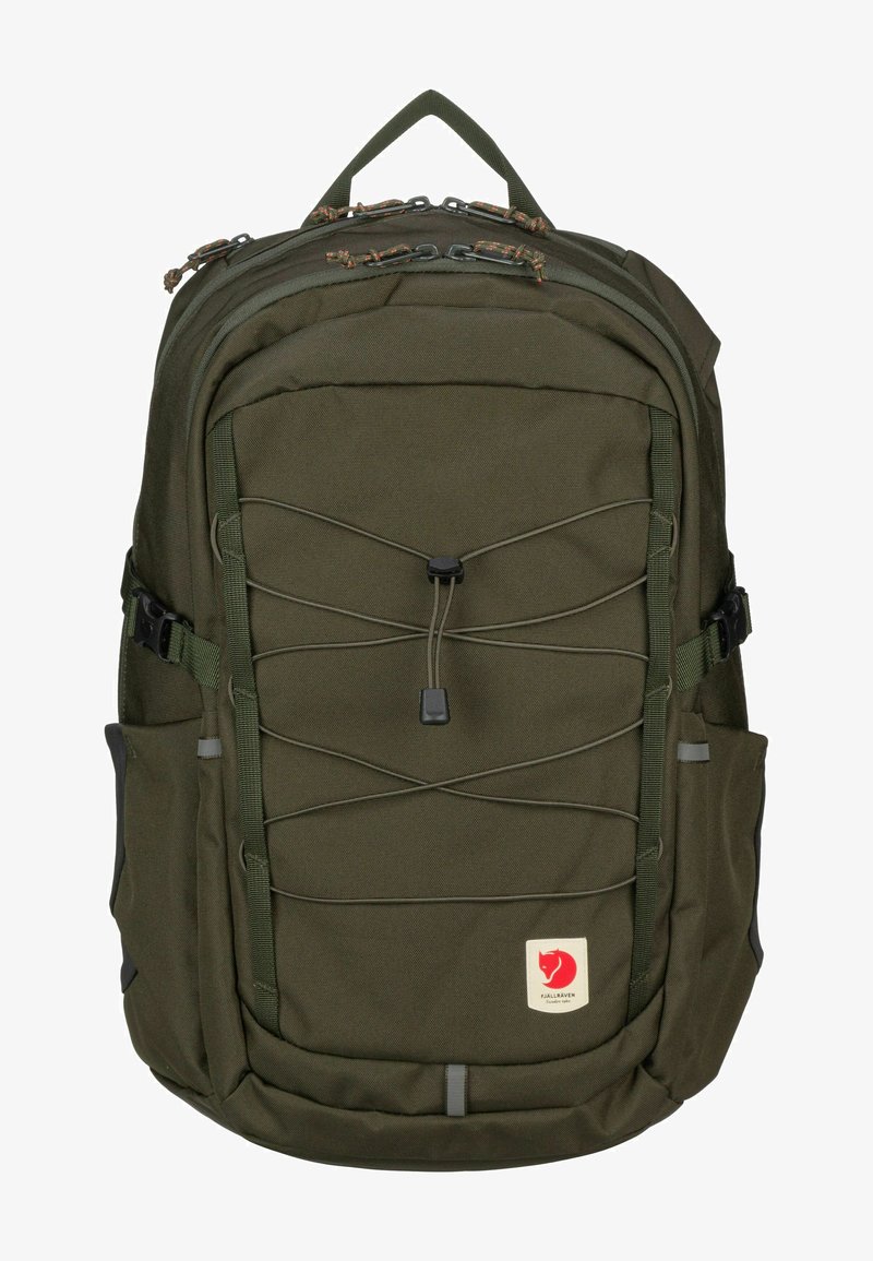 Sac à dos en tissu vert de forme rectangulaire. Il présente un design central en cordon bungee, plusieurs poches et un patch logo à l'avant.
