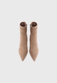 Beige suede ankle boots with a pointed toe, featuring a zipper on the side and a fitted design that hugs the ankle.