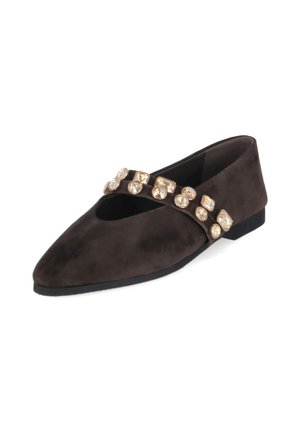 Zapato plano de ante negro con puntera puntiaguda y una correa decorada con grandes gemas doradas redondas y cuadradas.