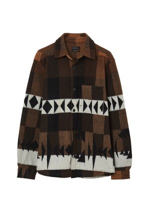 Chemise marron à motifs avec un design à carreaux, présentant un mélange d'accents noirs, blancs et bruns. Elle a un devant à boutons et une poche sur la poitrine.