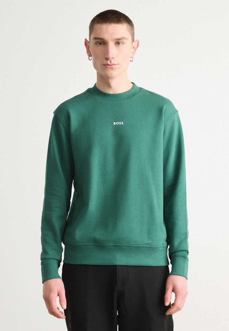 Sudadera de algodón verde con mangas largas, cuello redondo y puños acanalados. Presenta el logo 'BOSS' en blanco en el pecho, con una textura suave.