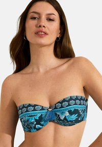 Bandeau badmode bovenstuk in donkerblauw met bloemenpatronen in turquoise en wit. Kenmerkt zich door een centrale versiering met een blauwe kwast. Gladde stof.