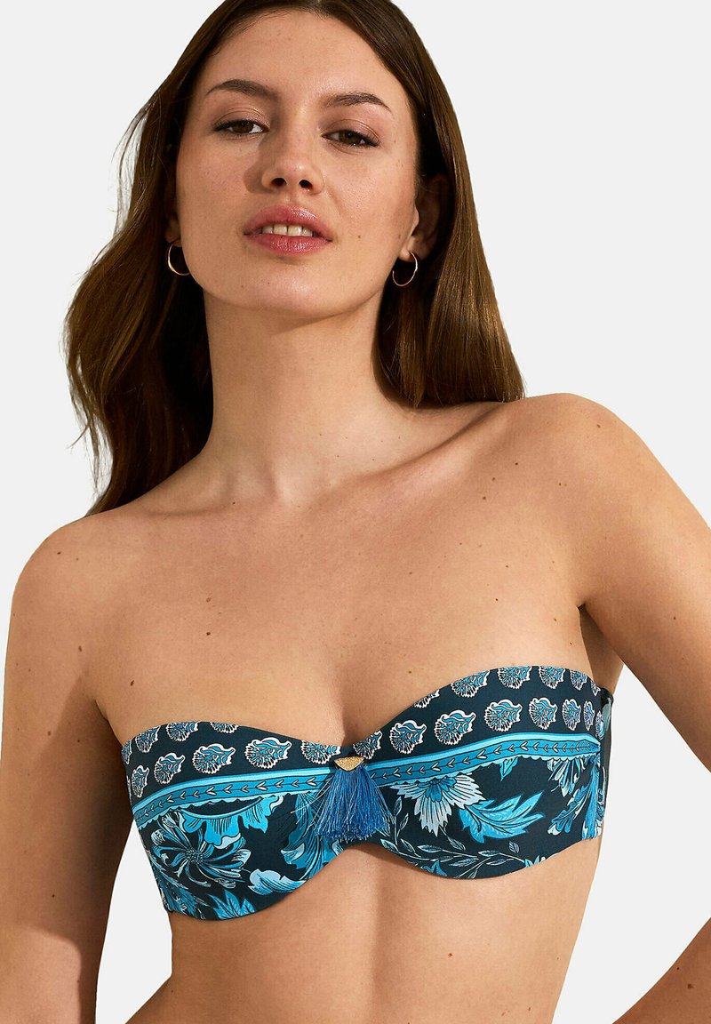 Bandeau badmode bovenstuk in donkerblauw met bloemenpatronen in turquoise en wit. Kenmerkt zich door een centrale versiering met een blauwe kwast. Gladde stof.