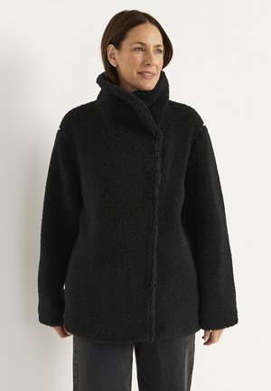 Schwarze Fleecejacke mit hohem Kragen, lässigem Schnitt und strukturiertem Stoff. Verfügt über einen Frontverschluss und Taschen an den Seiten.