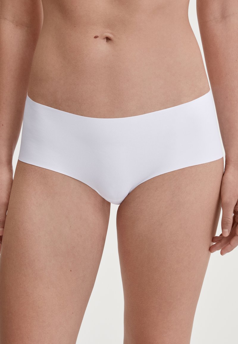 Sous-vêtements blancs dans un style hipster, fabriqués avec un tissu lisse et extensible, une taille plate et des bords sans couture pour un confort optimal et une coupe épurée.