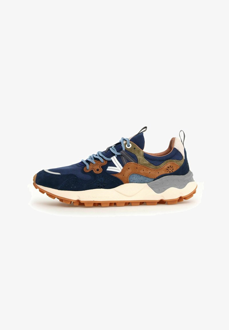 Marineblaue Sneakers aus Wildleder, Mesh und synthetischen Materialien. Merkmale sind braune und grüne Akzente, hellblaue Schnürsenkel und eine strukturierte Gummisohle.