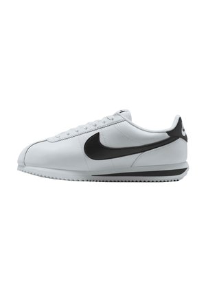 Zapatilla deportiva blanca de corte bajo con el logo Nike negro y detalle en el talón, cierre con cordones y suela texturizada vista de lado.