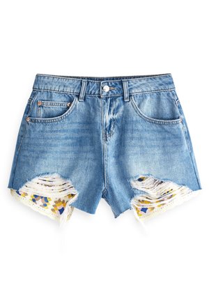 Blaue Denimshorts mit ausgefransten Säumen und floraler Spitzenstoff, sichtbar durch zerrissene Details auf der Vorderseite.