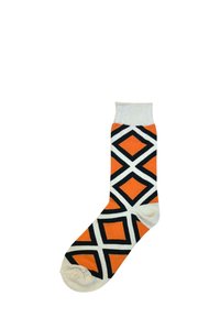 Orange sokker med en cremefarvet manchet, der har et geometrisk mønster af sorte diamanter omkranset af creme. Blødt tekstil med en tætsiddende pasform.