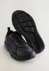 Schwarze Sportschuhe mit strukturiertem Obermaterial, lila Akzenten und gepolstertem Kragen. Sie verfügen über ein gemustertes Design und eine dicke, strapazierfähige Sohle.