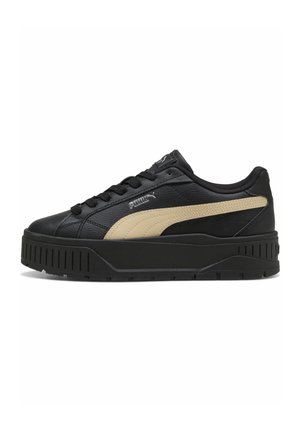 Czarny niski sneaker z grubą podeszwą, beżowym paskiem Puma po boku, czarne sznurowadła i logo Puma blisko sznurowadeł i języka.