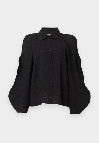 Μαύρο υφασμάτινο μπλουζάκι με κουμπιά, με δομημένους, φουσκωτούς όγκους στους ώμους και κλασικό μυτερό γιακά.
