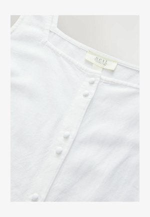 Top senza maniche in lino bianco con scollatura dritta, dotato di chiusura frontale con bottoni bianchi tondi e un'etichetta che indica il contenuto del materiale.
