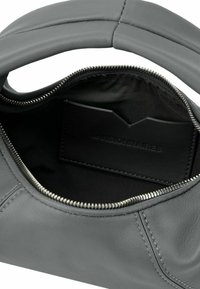 Interno di una borsa in pelle grigia con apertura con zip, caratterizzato da una superficie liscia e una fessura per carte in pelle nera.