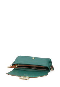 Sac en cuir vert avec une texture lisse, quincaillerie dorée, fermeture magnétique et un compartiment zippé. L'intérieur présente des accents marron contrastants.