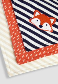 Tre quadrati di tessuto: uno con strisce diagonali blu navy e bianche con il viso di una volpe, uno arancione con pois bianchi e uno a strisce color crema.