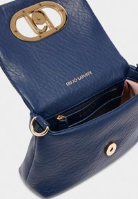 Borsa a mano blu navy realizzata in pelle texturizzata. Presenta una chiusura decorativa in tonalità oro e una zip interna, con il marchio "LIU JO LAPUFFY."