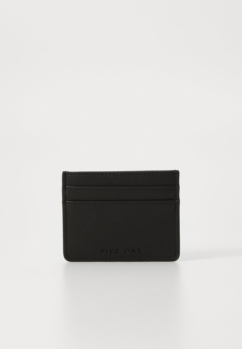 Black leather cardholder with a smooth texture, featuring four card slots and embossed logo detail on the front.