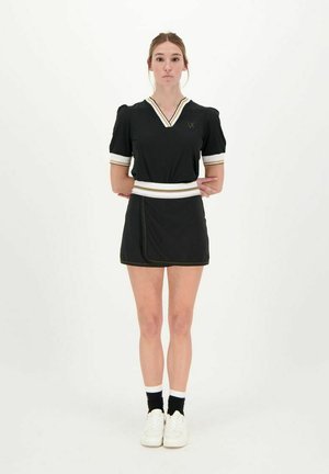 Zwart kortom kleding met korte mouwen, een V-hals en een witte elastische tailleband, met een gelaagde rok en gouden accenten. Gekocht met witte schoenen en sokken.