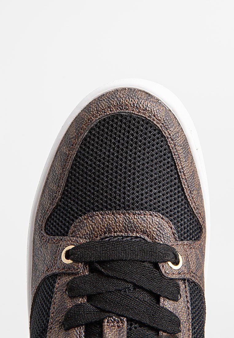 Scarpa atletica nera in rete con una punta in pelle marrone testurizzata, suola bianca, lacci neri e occhielli dorati per un tocco di dettaglio.
