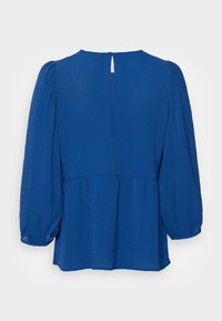 Blå blus med puffärmar och nyckelhålsrygg. Tillverkad av textil med struktur, med en peplumdesign och mjuka veck för en avslappnad passform.