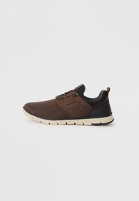 Baskets en cuir marron avec un talon noir texturé, design à lacets et semelle en caoutchouc crème. Présente des détails de logo subtils sur le côté.