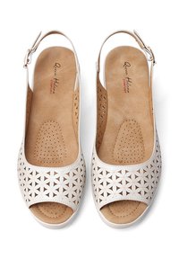 Sandali slingback bianchi con punta aperta, soletta perforata e insole color beige con motivi a raggiera, dotati di cinturino alla caviglia regolabile.