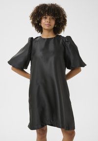 Svart satin klänning med puffade korta ärmar och rund halsringning. Slät textur och lös passform, som slutar strax ovanför knäna.