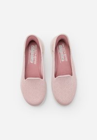Zapatillas de slip-on rosa claro con un patrón tejido texturizado, entrada elástica y interior acolchado. Suela suave y diseño casual para un uso fácil.