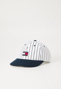 White baseball cap with navy brim, pinstripe design, and a red and black "TOMMY JEANS" logo patch on the front. Cotton material.