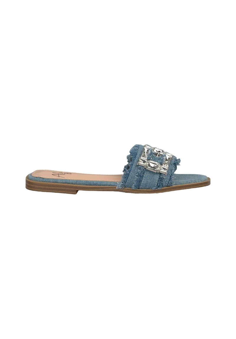 Sandalo in denim con bordi sfrangiati, grande fibbia decorativa in argento, suola piatta e colore azzurro chiaro. Design minimalista e punta aperta.