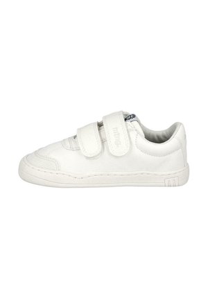 Zapatilla baja blanca con dos correas de Velcro ajustables y suela de goma, diseñada para uso casual.