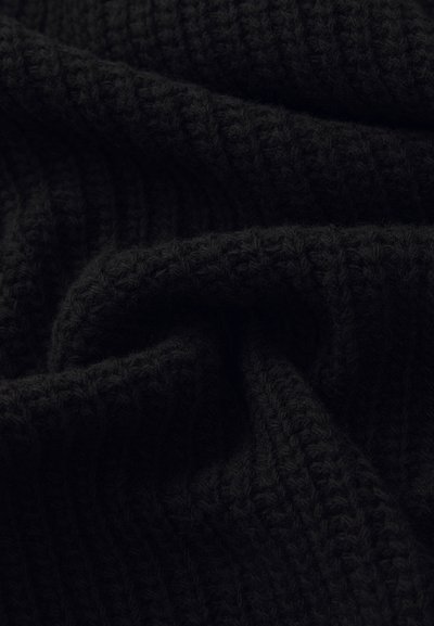 Tissu noir côtelé avec une surface douce et texturée, mettant en valeur de profonds plis qui soulignent son matériau et son design tricoté.