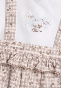 Robe en tartan rose avec des lapins blancs brodés. Présente des bordures froncées et des accents floraux sur le tissu, en coton doux.