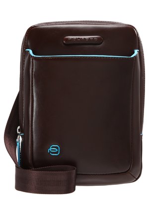 Bruine leren schoudertas met turquoise accenten, rechthoekige vorm, verstelbare schouderband, voorzak met rits en een textuur oppervlak.