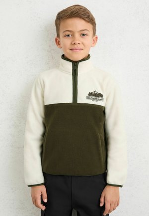 Pulover fleece în culoare alb-crem și verde închis, cu guler înalt, fermoar scurt în față și logo montan brodat pe piept.