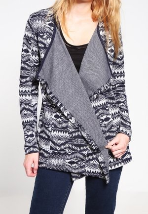 Cardigan à manches longues avec un motif géométrique bleu marine et blanc ; dispose d'un design en contraste gris à l'avant avec une texture douce.