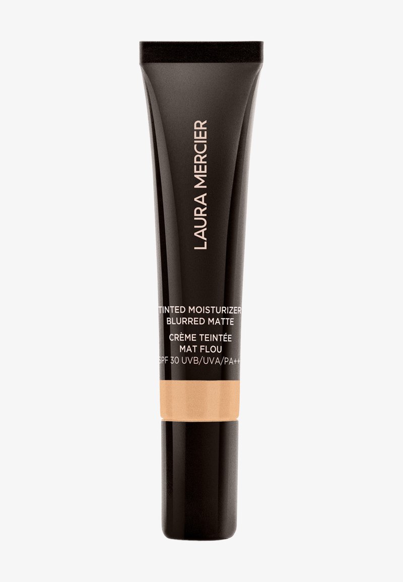 Laura Mercier fargetilpasset fuktighetskrem i en svart tube med matt finish. Har fet tekst og en beige seksjon som angir SPF 30 for solbeskyttelse.