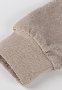 Hellbeiger Sweatshirtbund mit einem weichen, strukturierten Fleecefutter im oberen Bereich und einem glatten Strickabschluss im unteren Abschnitt.