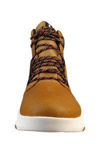 Brązowe skórzane buty typu high-top z czarnym siateczkowym językiem, pomarańczowo-czarnymi sznurówkami w wzory oraz białą, teksturowaną podeszwą.