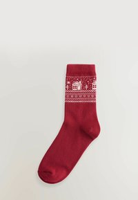 Rote gestrickte Socke mit weißen winterlichen Mustern, darunter Häuser und Bäume, mit einem gerippten Bündchen und glatter Textur.