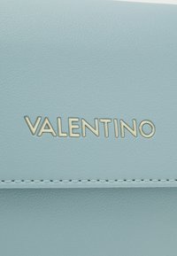 Světlomodrá kožená peněženka s hladkou texturou, zlatým logem "Valentino" a bílým prošitím podél okraje.