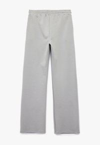 Lys grå sweatpants lavet af blødt stof, med en justerbar talje, brede ben og uden synlige mønstre eller hardware detaljer.