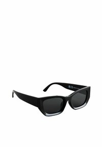 Lunettes de soleil noires avec une monture carrée épaisse ; verres teintés sombres avec un dégradé subtil ; texture lisse avec une marque visible sur la branche.