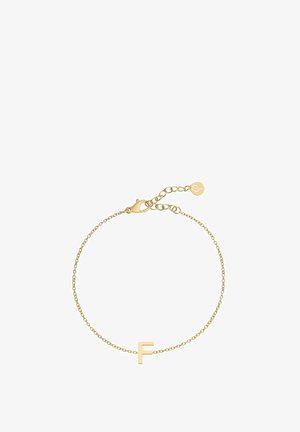 Bracelet en chaîne dorée avec un charme en forme de lettre "F". La chaîne est délicate avec un fermoir lobster et une longueur ajustable. Fini en métal lisse.