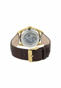 Goldene Uhr mit transparentem Gehäuse, das die mechanische Bewegung zeigt, braunem Lederarmband und goldener Schnalle, die mit "JOOP!" graviert ist.