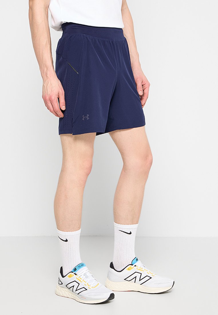 Marineblauwe sportshorts met een elastische tailleband en zijzak, gemaakt van lichtgewicht stof, met een ademende textuur en logodetail.