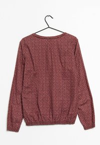 Chemisier à manches longues, bordeaux, avec un petit motif floral blanc, col rond et taille élastiquée pour un effet froncé.