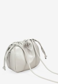 Bolso de cuerda de cuero gris con forma redondeada, textura suave y correas ajustables. Presenta una parte superior fruncida y un diseño minimalista.