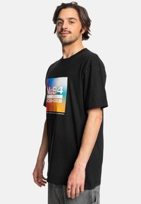 Zwarte katoenen t-shirt met korte mouwen, voorzien van een kleurrijk grafisch ontwerp op de voorkant met de tekst "No 94 DC SHOES" en een rechthoekige vorm.